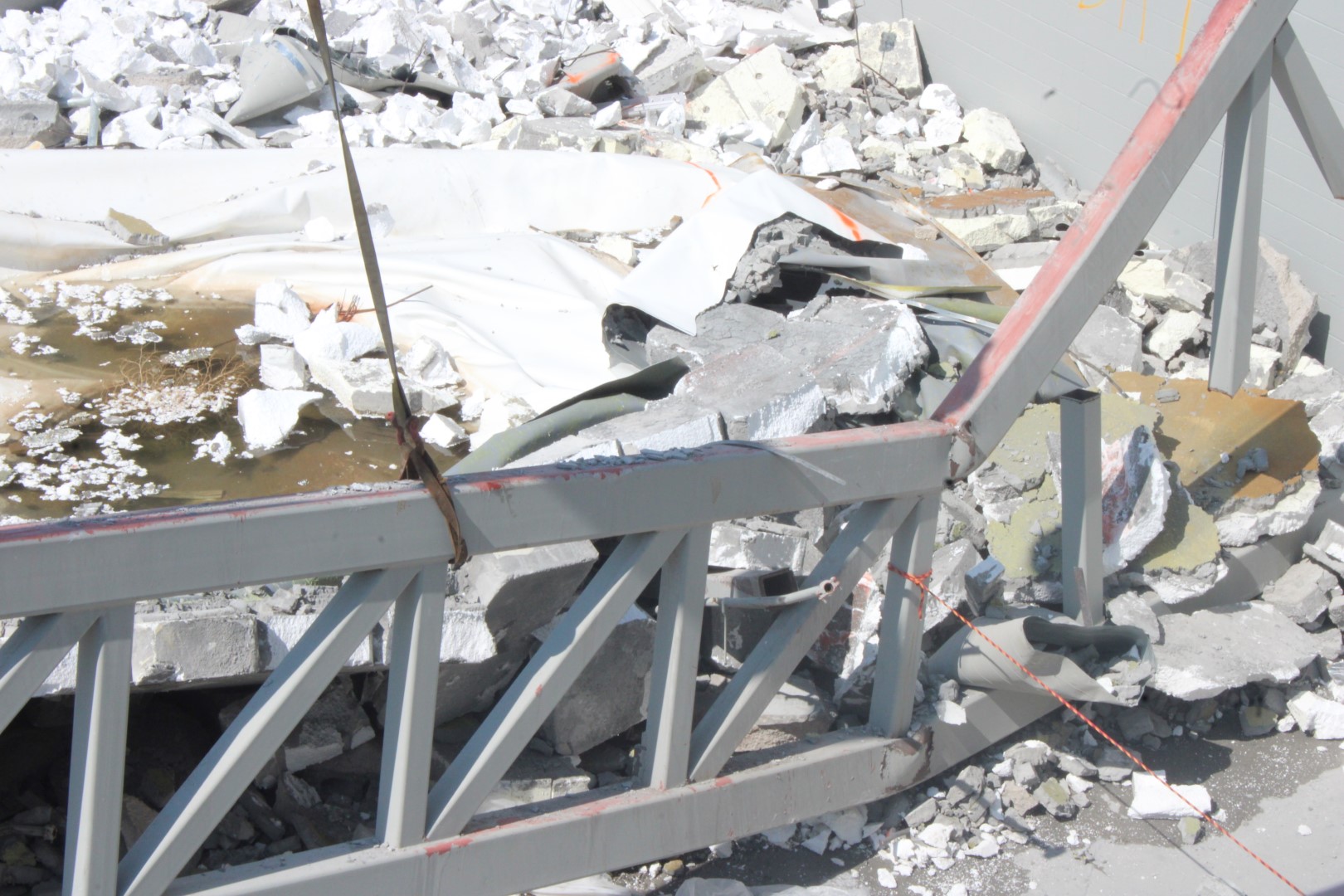 A forensic engineer documenting structural damage at a commercial property site